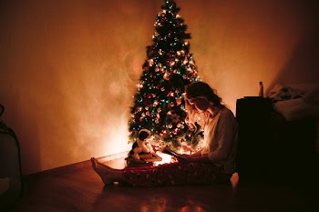 Photo of Woman Sitting Near the Christmas Tree