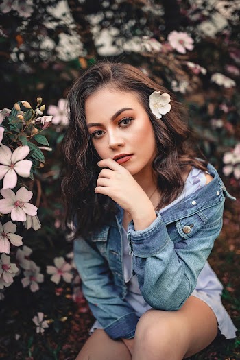 Photo of Woman Sitting Near White Flowers