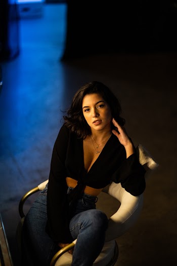 Photo of Woman Sitting on Armchair Posing While Looking Up