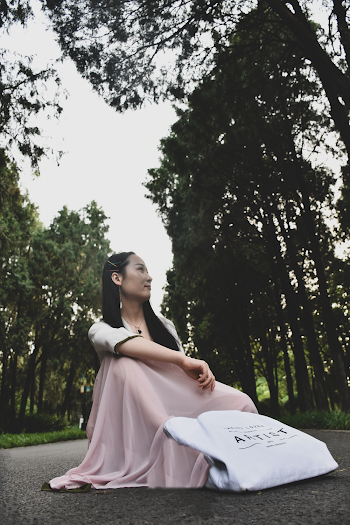 Photo of Woman Sitting on Asphalt Road