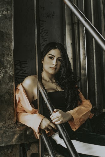 Photo of Woman Sitting on Black Metal Stairs