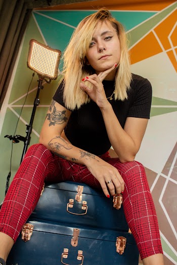Photo of Woman Sitting on Blue Suitcases While Holding Her Chin