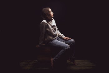 Photo of Woman Sitting on Brown Wooden Box