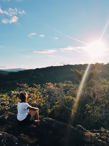 Photo of Woman Sitting on Cliff