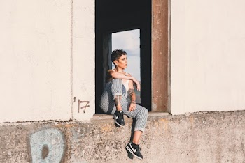 Photo Of Woman Sitting On Concrete Surface