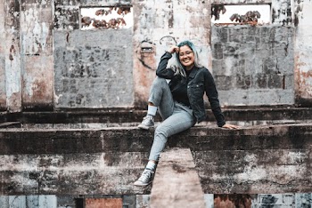 Photo Of Woman Sitting On Concrete Surface