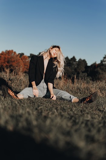 Photo Of Woman Sitting On Grass Field