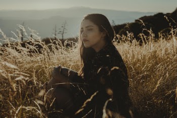 Photo of Woman Sitting On Grass Field