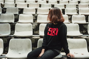 Photo of Woman Sitting on Gray Bleacher Chair