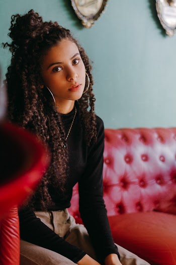 Photo of Woman Sitting on Red Sofa