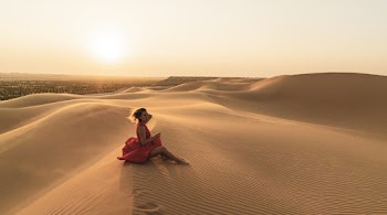 Photo Of Woman Sitting On Sand 