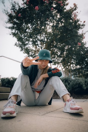 Photo of Woman Sitting on the Floor Doing the Peace Sign