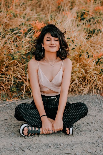 Photo of Woman Sitting on the Ground with Her Eyes Closed