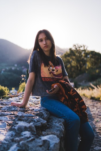 Photo Of Woman Sitting On Top Of Rock