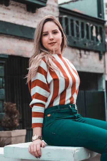 Photo of Woman Sitting on White Stone Bench