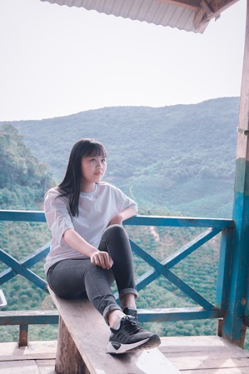 Photo of Woman Sitting on Wooden Bench
