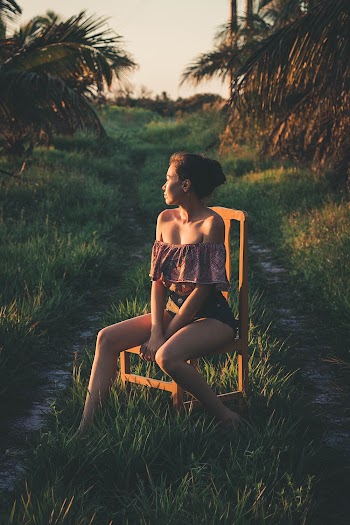 Photo of Woman Sitting on Wooden Chair