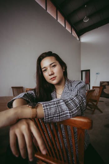 Photo Of Woman Sitting On Wooden Chair