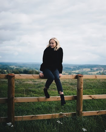 Photo of Woman Sitting on Wooden Fence