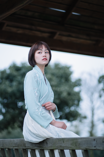 Photo Of Woman Sitting On Wooden Handrail