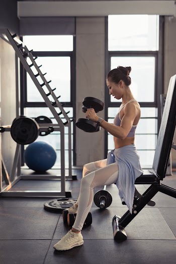 Photo of Woman Sitting While Holding Dumbbells