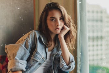 Photo of Woman Sitting With Her Hand on Her Cheek