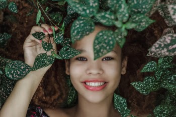 Photo of Woman Smiling Near Leaves