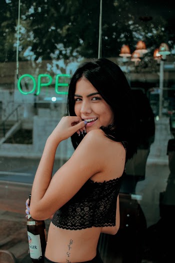 Photo of Woman Smiling While Holding Bottle