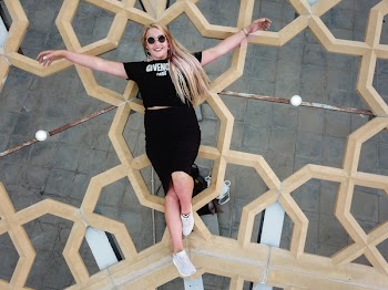 Photo of Woman Smiling While Lying on Brown Frame