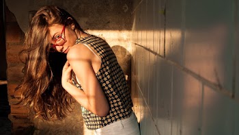 Photo of Woman Standing and Leaning Against the Wall
