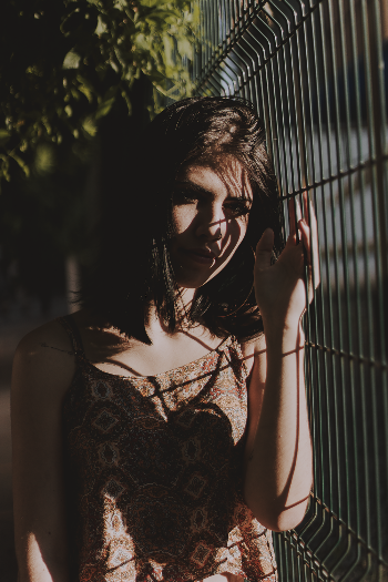 Photo of Woman Standing Beside Black Metal Fence
