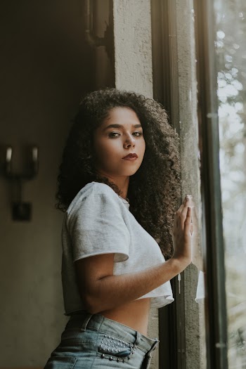 Photo of Woman Standing Beside Glass Wall