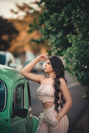Photo of Woman Standing Beside Green Volkswagen Beetle Posing