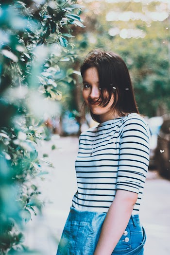 Photo of Woman Standing Beside Leaves