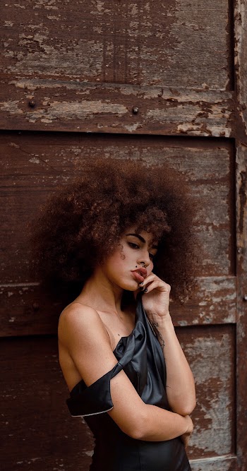 Photo of Woman Standing Beside on Brown Door Posing