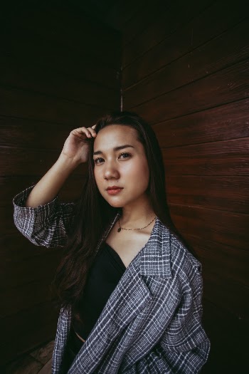 Photo Of Woman Standing Beside Wooden Wall 