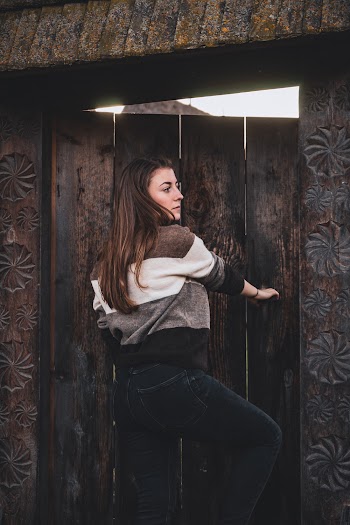Photo of Woman Standing By Wooden Door Looking Away
