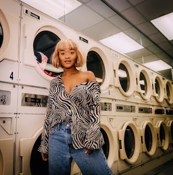 Photo of Woman Standing In Front of Washing Machines at Laundromat