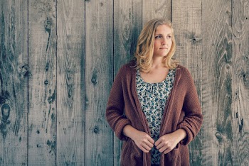 Photo of Woman Standing In Front of Wooden Wall Looking Away