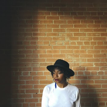 Photo Of Woman Standing Near Brick Wall