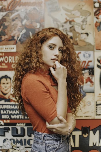 Photo Of Woman Standing Near Comics