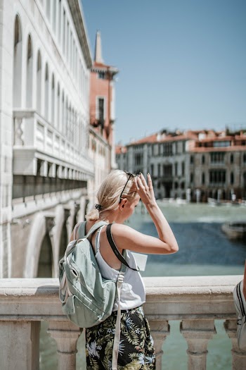 Photo Of Woman Standing Near Concrete Fence