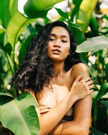 Photo of Woman Standing Near Green Leaves