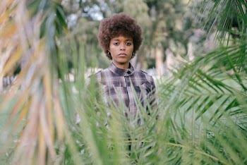 Photo Of Woman Standing Near Leaves