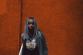 photo of woman standing near red painted wall