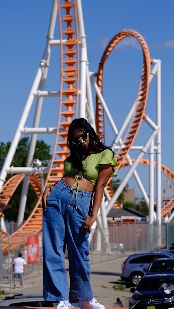 Photo Of Woman Standing Near Roller Coaster
