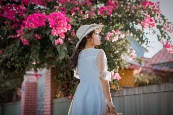 Photo Of Woman Standing Next To Pink Bougainvillea Flowers