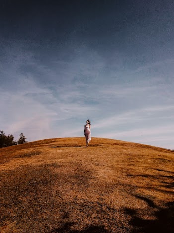 Photo of Woman Standing on Grass Hill