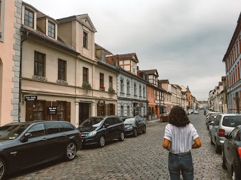 Photo of Woman Standing on Road Near Parked Cars