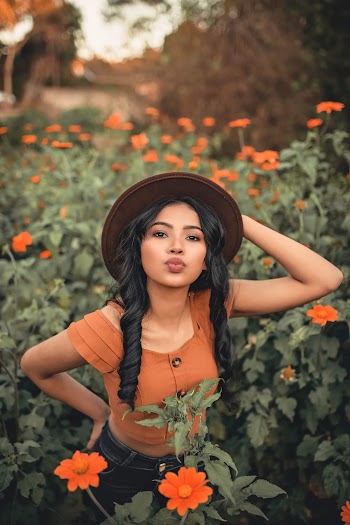 Photo of Woman Standing Standing in the Middle of a Flower Field Posing